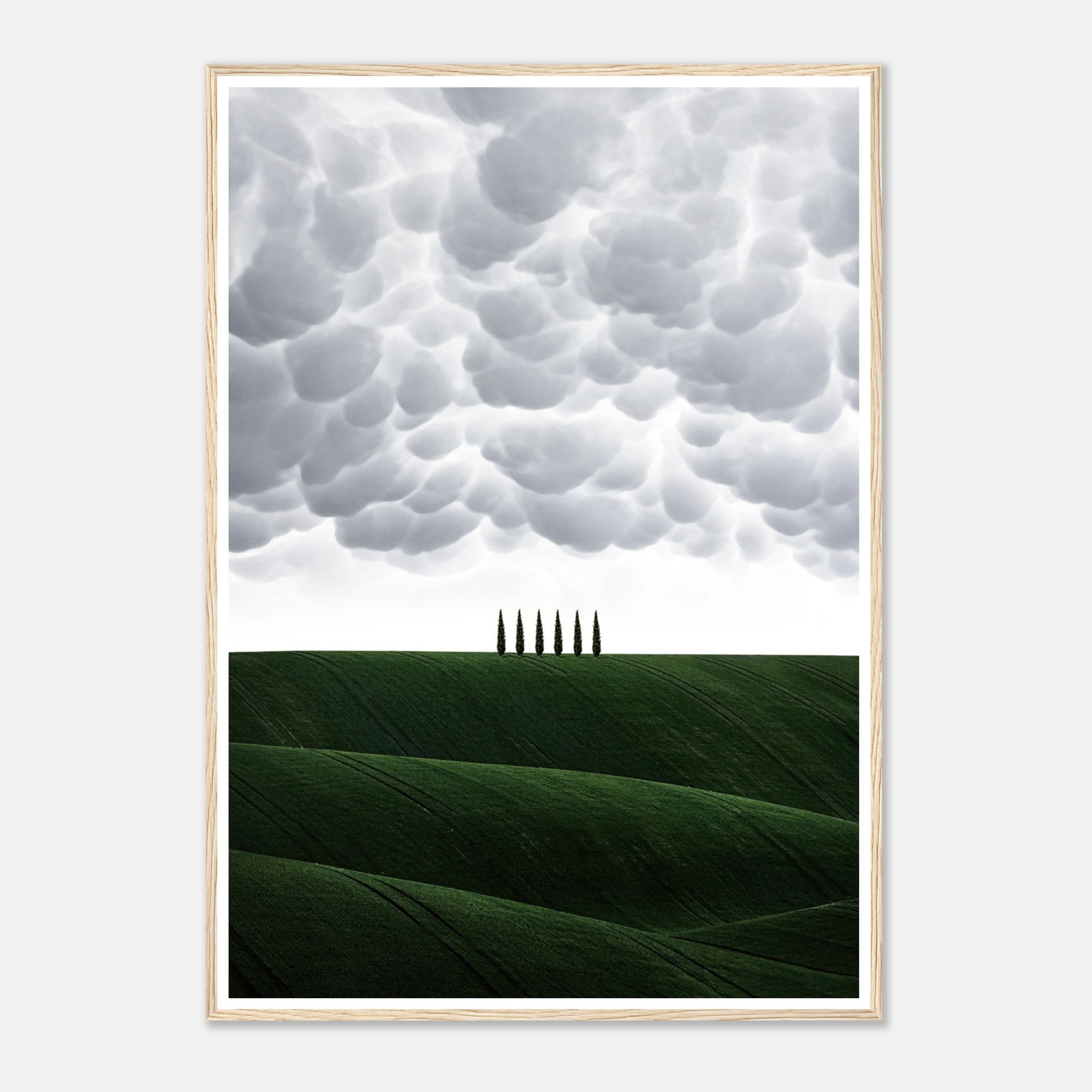 Toscana framed print featuring green hills and cypress trees under dramatic clouds, showcasing serene Italian countryside beauty.