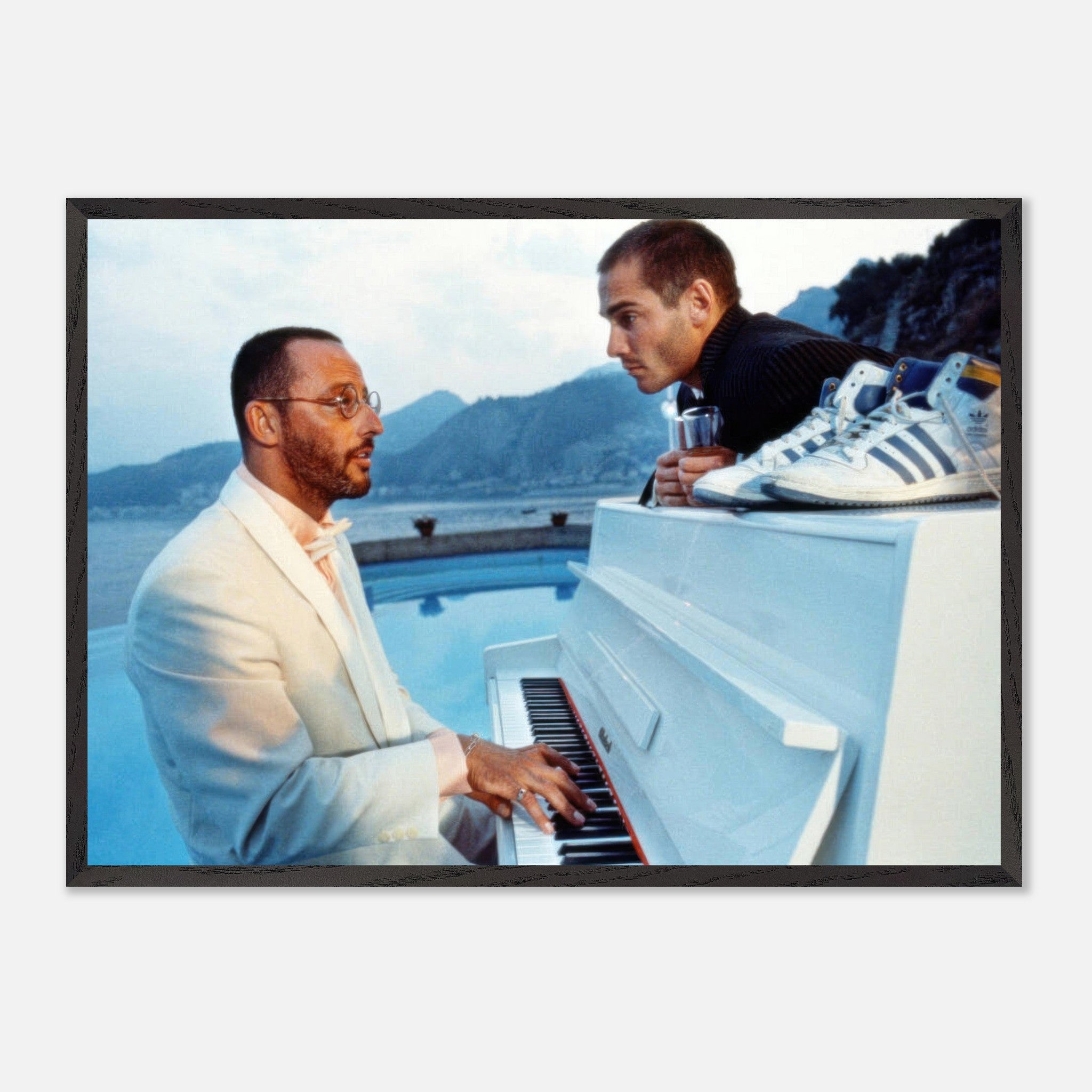 Jean Reno playing piano by the poolside with a scenic coastal backdrop, capturing a moment from *The Big Blue* fine art print.