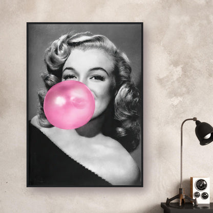 Framed print of Marilyn Monroe blowing pink bubble gum, adding glamour and quirk to any wall décor.