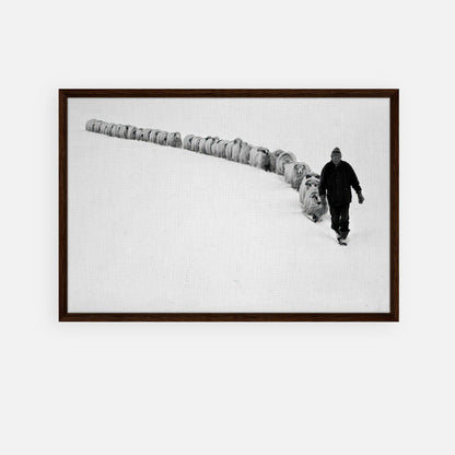 Framed canvas print of a shepherd walking through snow with his flock in black and white, symbolizing tradition and resilience.