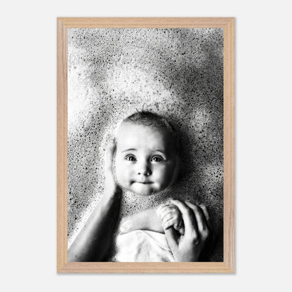 Stunning black-and-white baby bath photography capturing innocent joy and tenderness with soft bubbles surrounding a smiling baby.