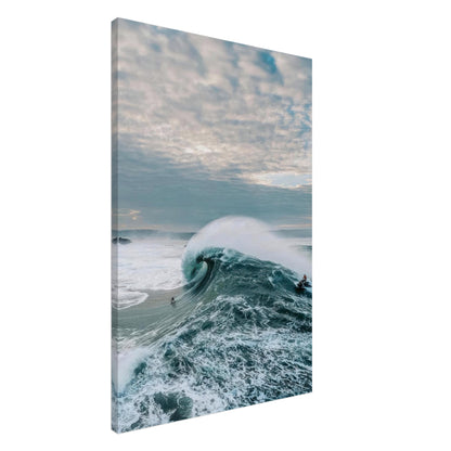 Big Wave Surfing Canvas Print depicting a surfer riding a massive ocean wave under a cloudy sky.