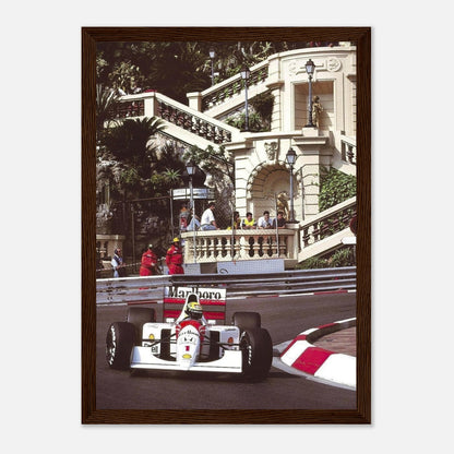 Framed print of Ayrton Senna racing at the Monaco Grand Prix, capturing a moment of speed and skill.