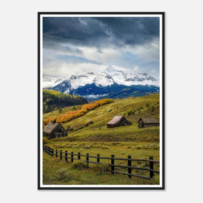 Framed print of Telluride, Colorado with rustic barns and snow-capped mountains under a dramatic sky.