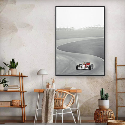 Framed print of Ayrton Senna racing the McLaren MP4/4 on track, stylishly displayed in a modern interior setting.