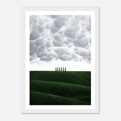 Framed print of Tuscany, Italy featuring green hills and cypress trees under dramatic cloud formations.