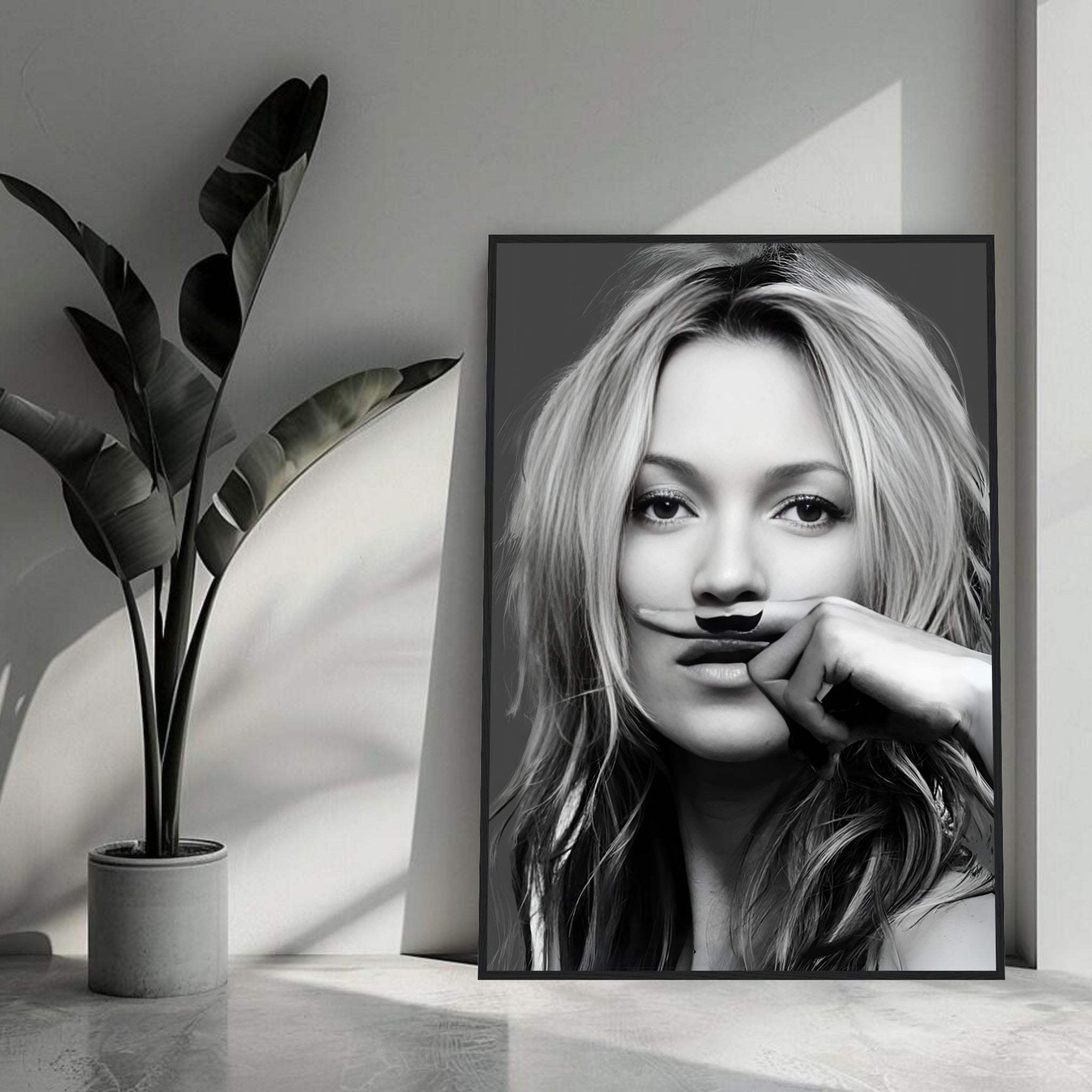 Kate Moss Mustache Framed Print showcasing a black-and-white portrait with a whimsical mustache, perfect for modern decor.