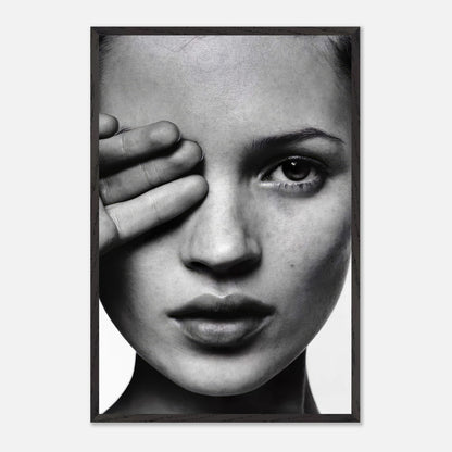 Black and white framed print of a woman covering one eye, showcasing elegance and timeless style.