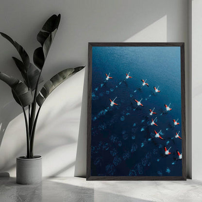 Aerial view of flamingos in motion over deep azure waters, captured in high-resolution fine art print.