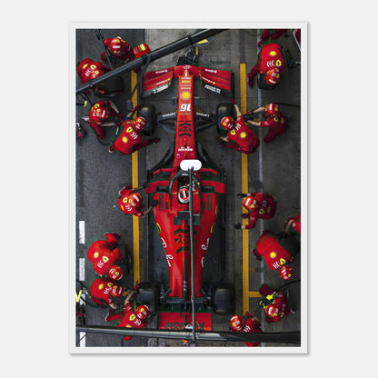 Dynamic Formula 1 Ferrari pitstop framed print showcasing intense pit crew action and vivid red colors.