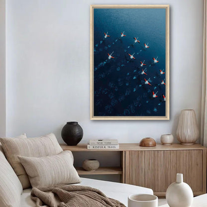 Framed canvas print of flamingos flying over blue waters in a stylish living room setting.