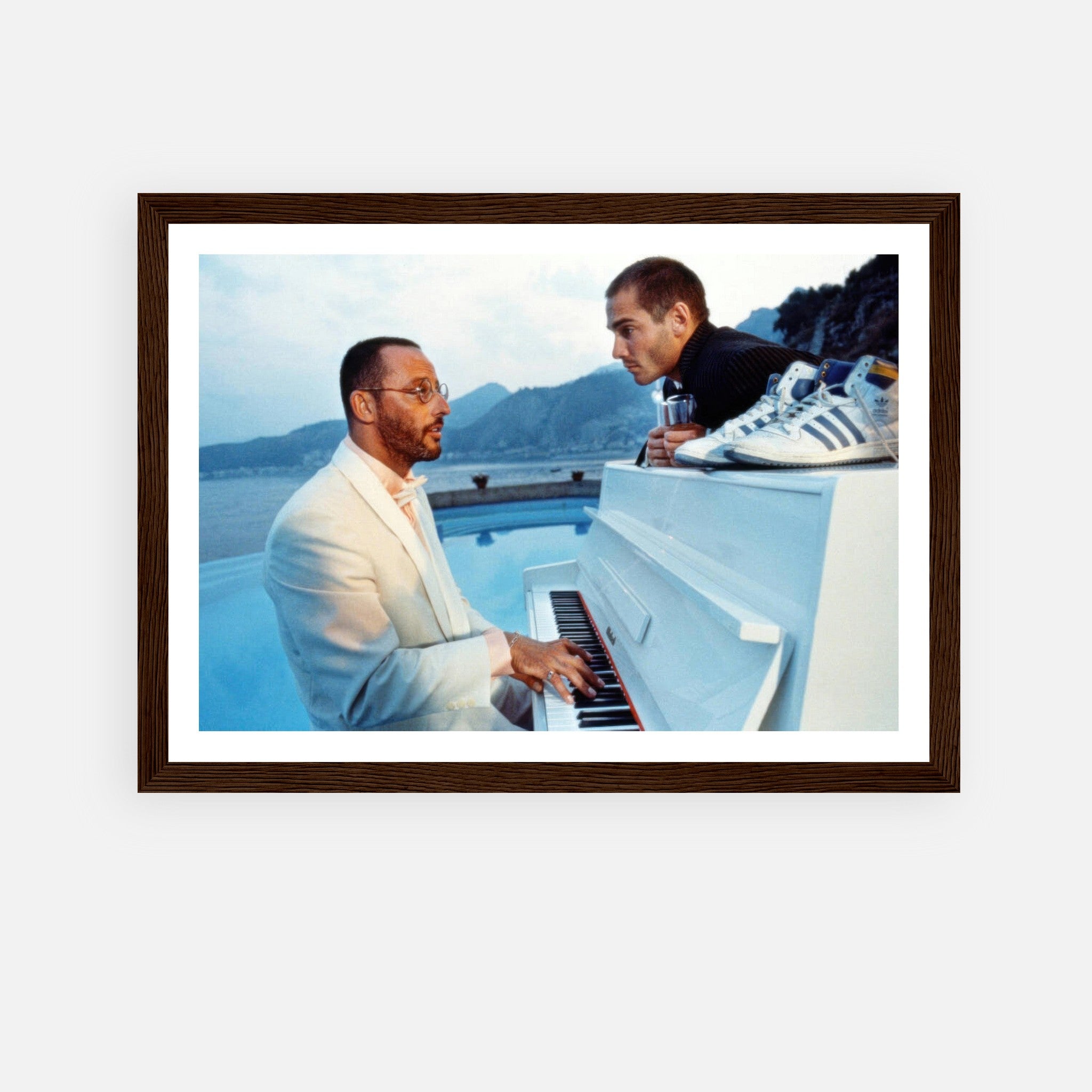 Jean Reno playing piano with a scenic ocean background in a framed print from "The Big Blue."