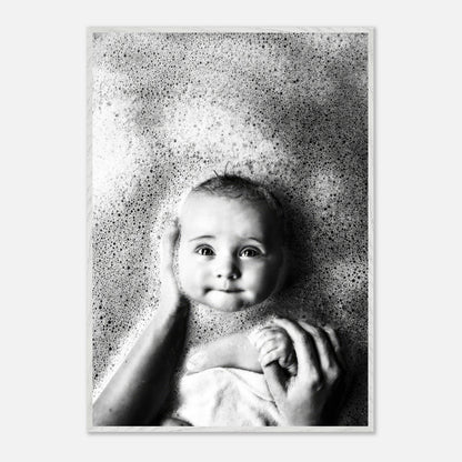 Black-and-white baby bath photography print showcasing a smiling baby surrounded by bubbles, conveying innocence and joy.