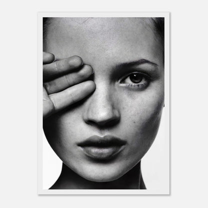 Black and white portrait of a woman with a hand covering one eye, showcasing striking beauty and modern elegance.