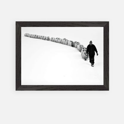 A shepherd guiding a flock of sheep through a snowy landscape in black-and-white framed art.
