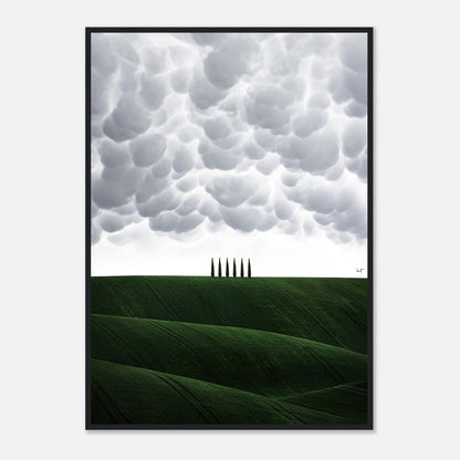 Framed print of Tuscany, Italy, featuring rolling green hills and cypress trees under dramatic clouds.