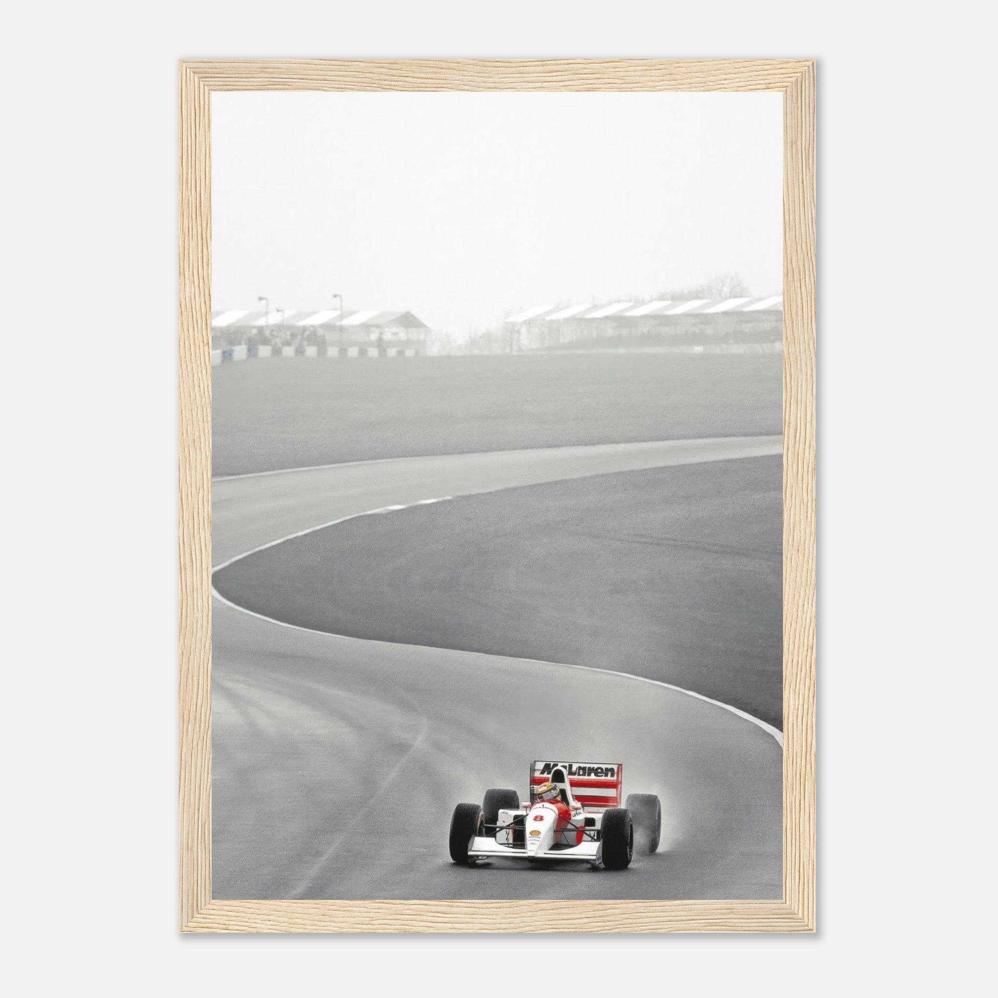 Framed black and white photo of Ayrton Senna driving the McLaren MP4/4 on a racetrack in 1988.