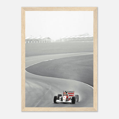 Framed black and white photo of Ayrton Senna driving the McLaren MP4/4 on a racetrack in 1988.