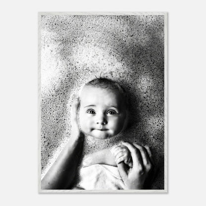 Black-and-white baby bath photography capturing pure joy and innocence surrounded by soft bubbles.
