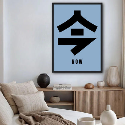 Now in Japanese Kanji Framed Print with black typography on serene blue background in stylish living room.