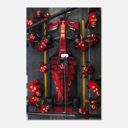 Ferrari F1 pitstop scene with team in red uniforms, showcasing dynamic racing action and brushed metal print texture.