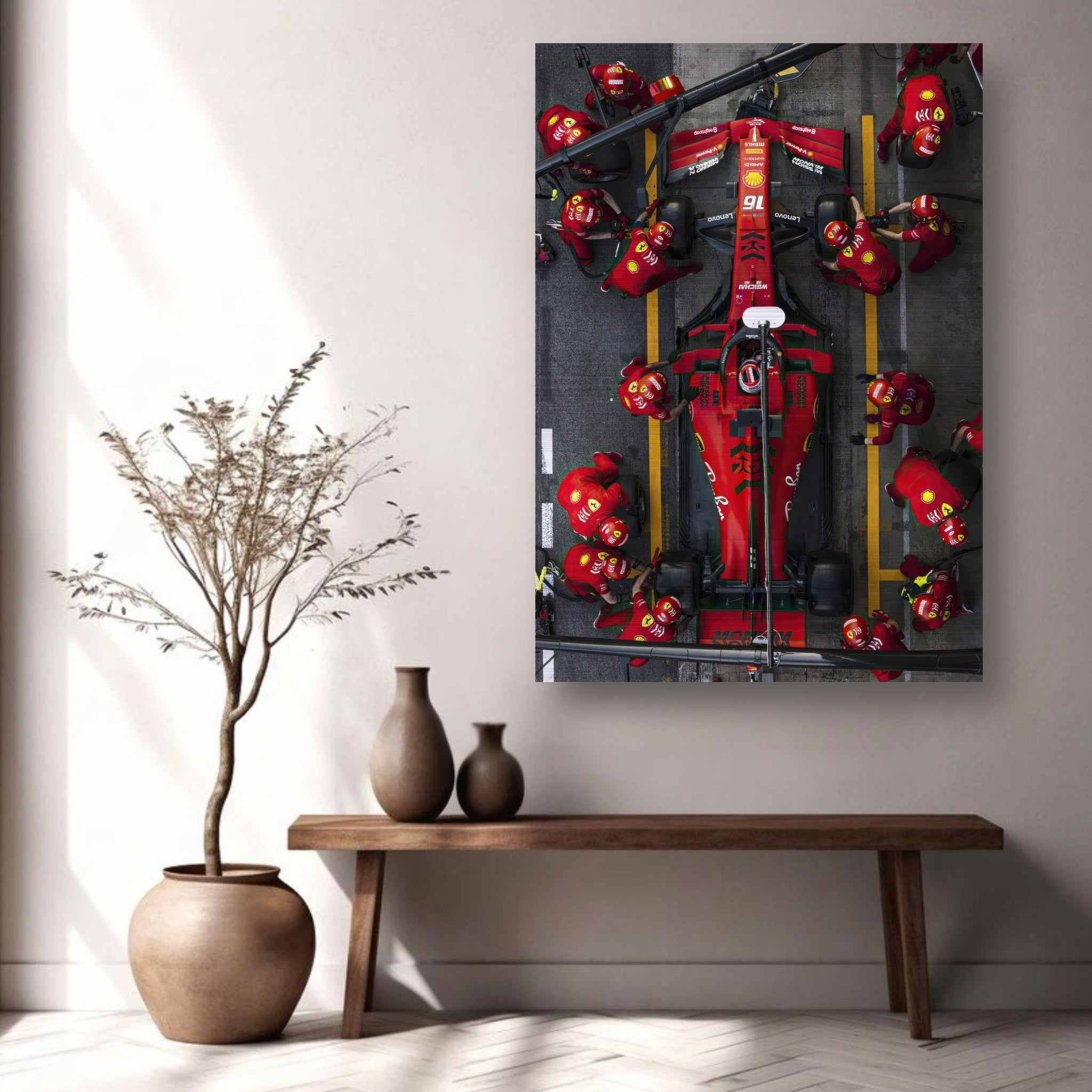 Brushed metal print of a Formula 1 Ferrari pitstop, showcasing vibrant colors and dynamic racing action on a stylish wall display.