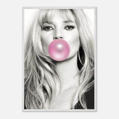 Vintage framed print of a black-and-white portrait of Kate Moss blowing pink bubble gum. Stylish and playful decor.