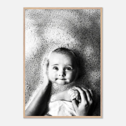 Black-and-white photo of a smiling baby in a bubble bath, showcasing innocence and joy in childhood.