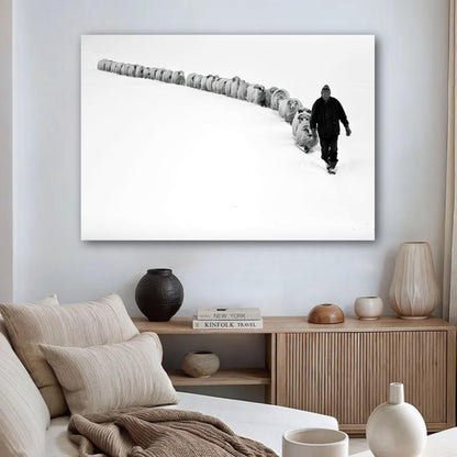 Shepherd leading flock in snow-covered landscape, showcasing nature's beauty in a minimalist metal print.