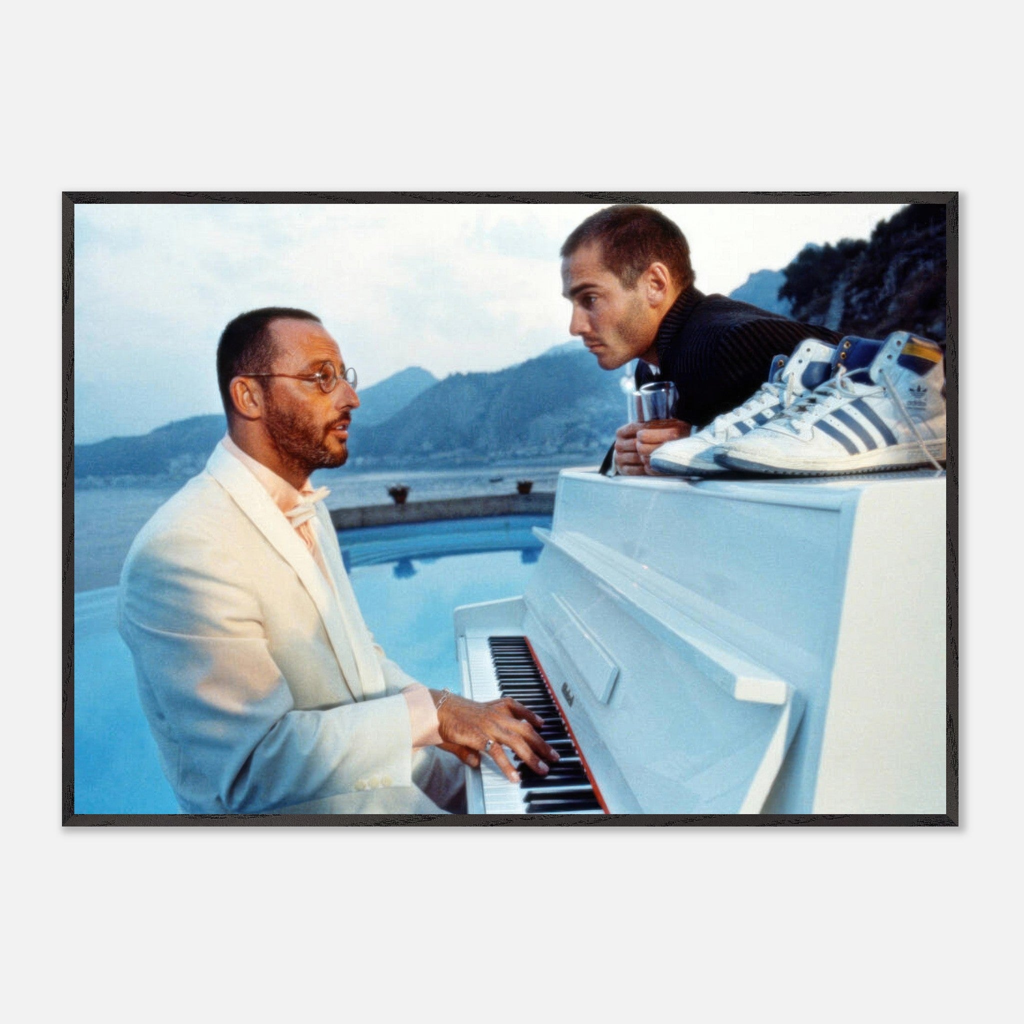 Jean Reno playing piano by the pool with a coastal backdrop and a man leaning in, inspired by *The Big Blue*.