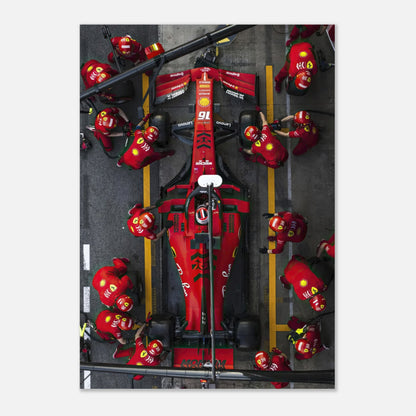 Ferrari pitstop metal print showcasing a dynamic scene with team members in red uniforms servicing the race car.