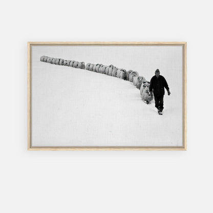 A lone shepherd leading a flock through a vast snow-covered landscape in this framed canvas print.