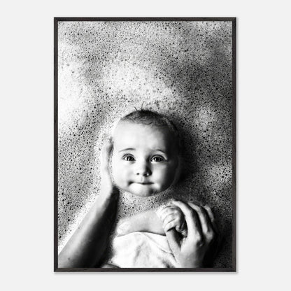Black-and-white fine art print of a smiling baby in a bubble bath, showcasing innocence and joy.