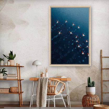 Framed canvas print of flamingos in flight over blue water, showcasing aerial drone photography in a stylish room.