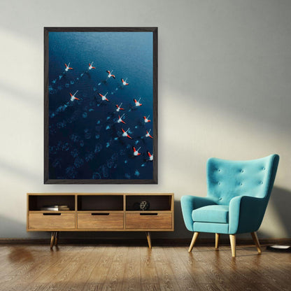 Framed aerial photograph of flamingos gliding over deep blue waters in a modern living room setting.