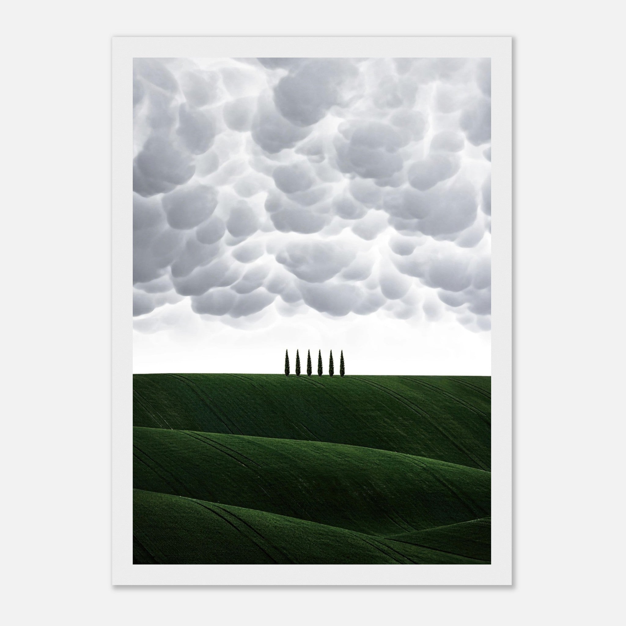 Framed print of Tuscan landscape with rolling green hills and dramatic clouds, featuring elegant cypress trees.