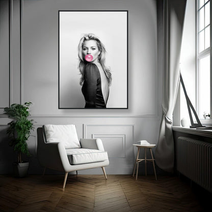 Framed print of Kate Moss blowing bubble gum, displayed in a modern room with stylish decor and natural light.