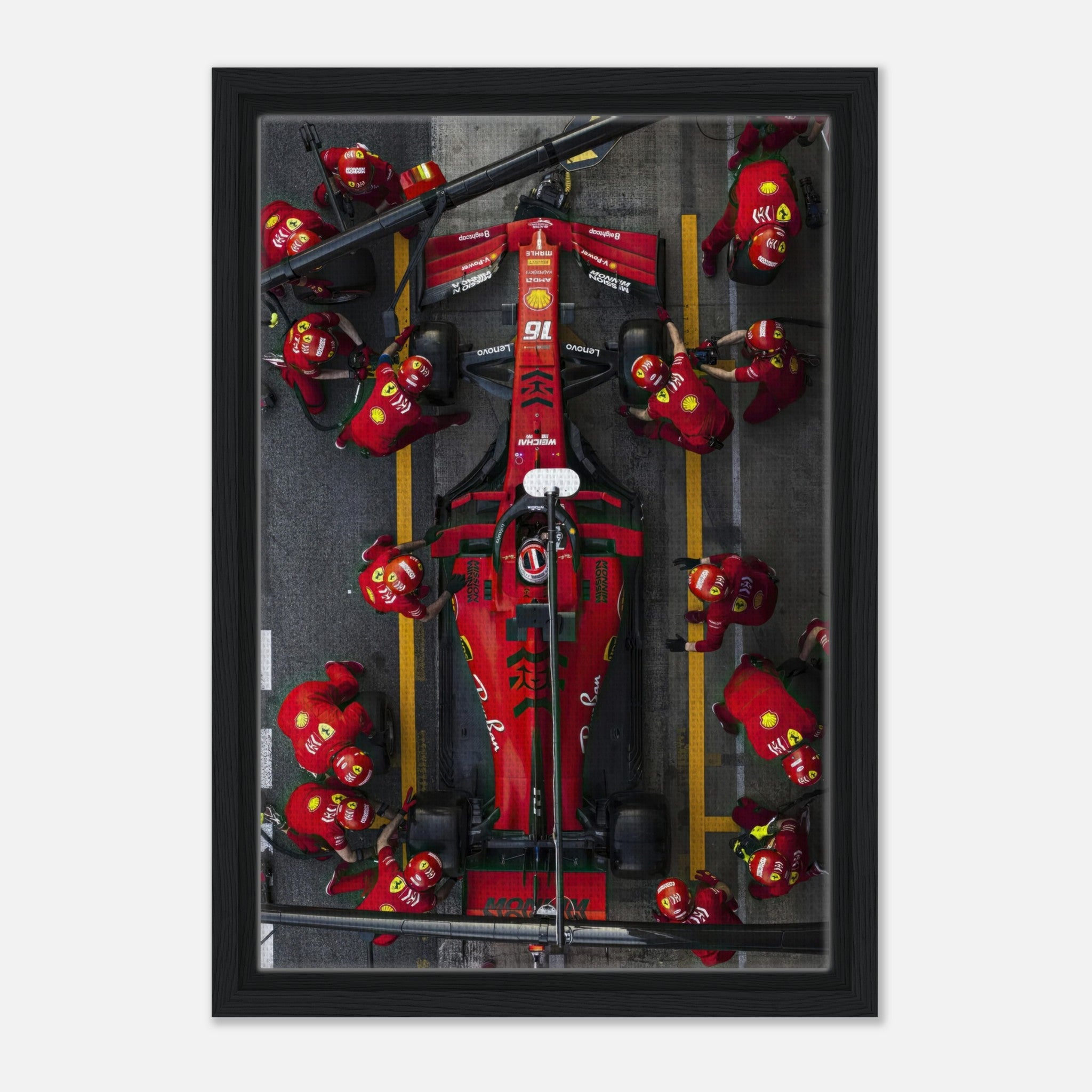 Framed canvas print of a thrilling Ferrari Formula 1 pitstop featuring team members in action. Perfect for motorsport décor.