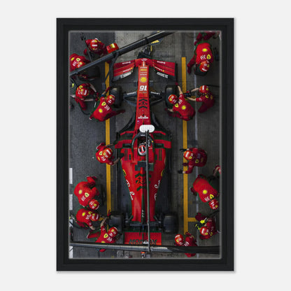 Framed canvas print of a thrilling Ferrari Formula 1 pitstop featuring team members in action. Perfect for motorsport décor.