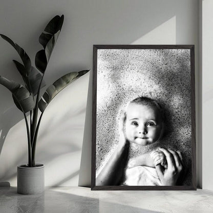 Black-and-white baby bath photography print showcasing a smiling infant surrounded by gentle bubbles.