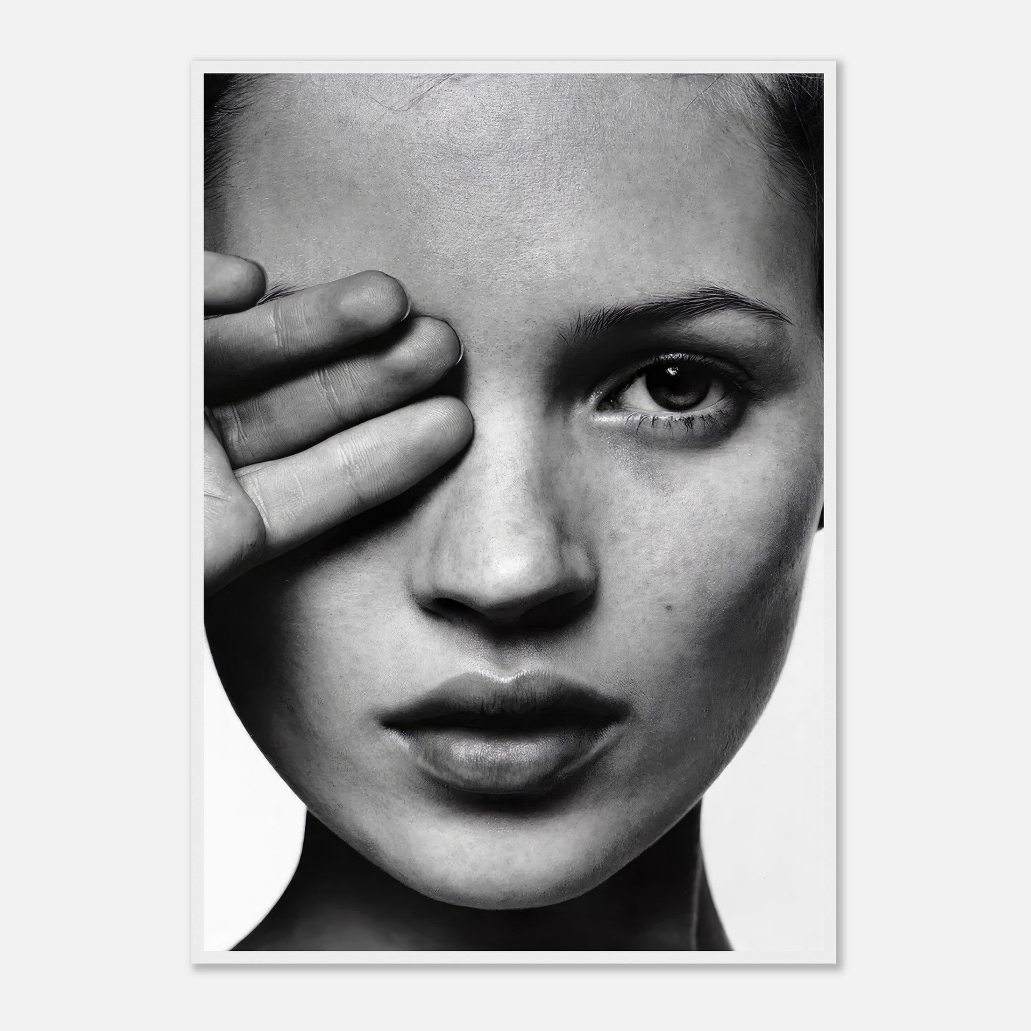 Black and white portrait of a model covering one eye with her hand, showcasing elegance and striking monochromatic contrasts.