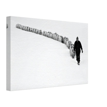 Black-and-white canvas print of a shepherd walking with his flock in a snow-covered landscape.