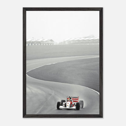 Framed Giclée artwork of Ayrton Senna racing in a McLaren MP4/4 on a curving track, capturing the spirit of Formula 1.