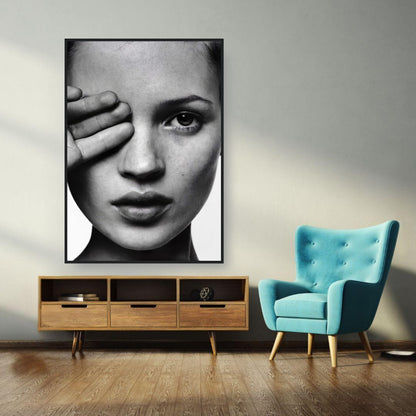 Black and white framed portrait of a model in a modern decor setting with a teal chair and wooden furniture.