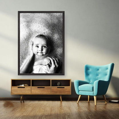 Black-and-white fine art print of a baby enjoying a bath, capturing joy and innocence in a serene setting.