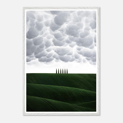 Vintage framed art of Tuscany's rolling green hills and cypress trees against a dramatic cloudy sky.