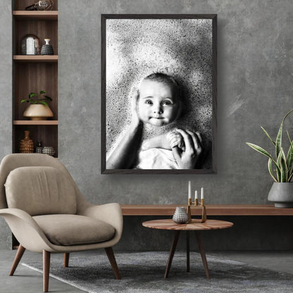 Black-and-white baby bath photography art print capturing a smiling baby surrounded by bubbles, framed in a modern interior.
