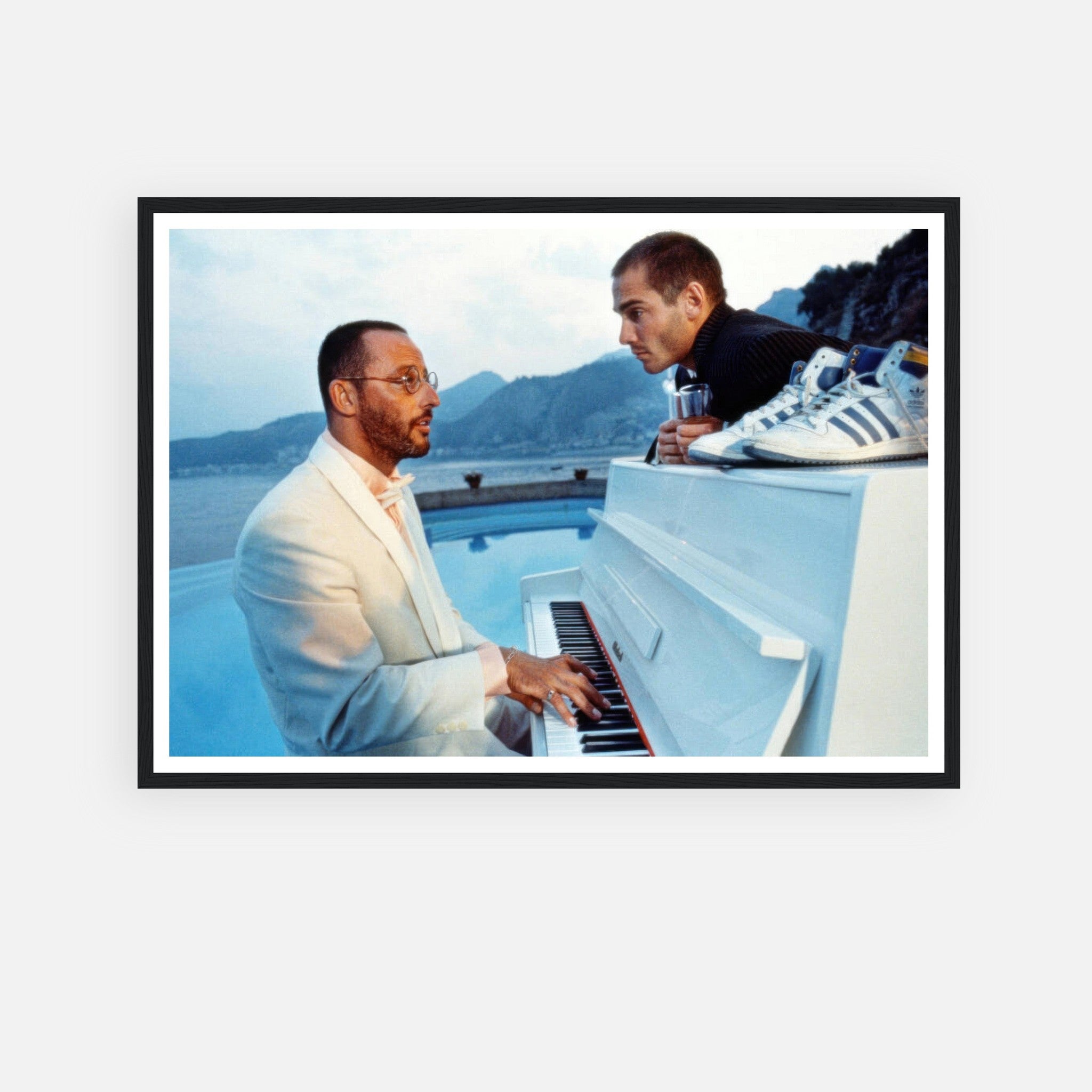 Jean Reno playing piano with a serene mountain backdrop in a framed print from "The Big Blue" movie scene.