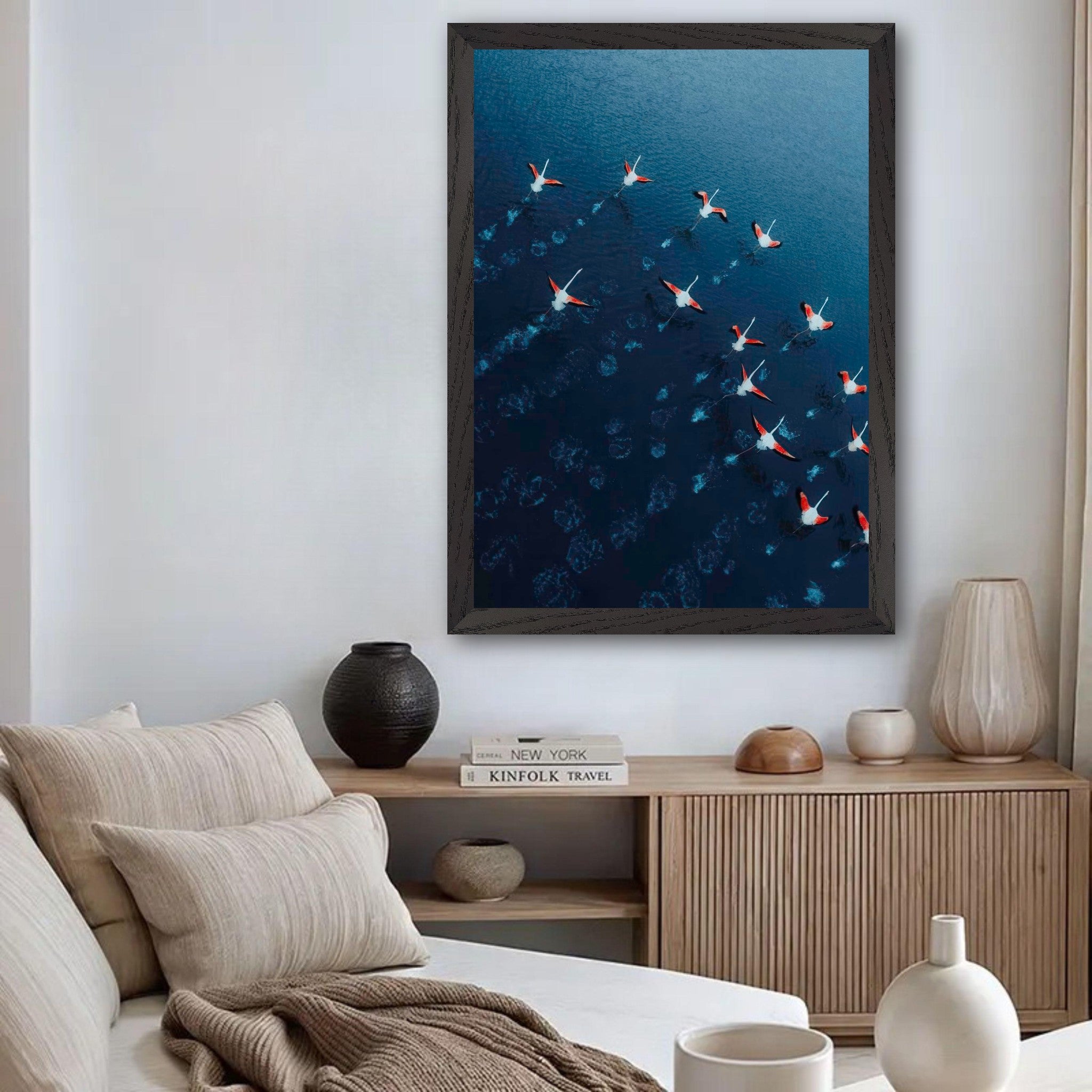 Framed print of flamingos in flight over blue waters, adding elegance to any living space.