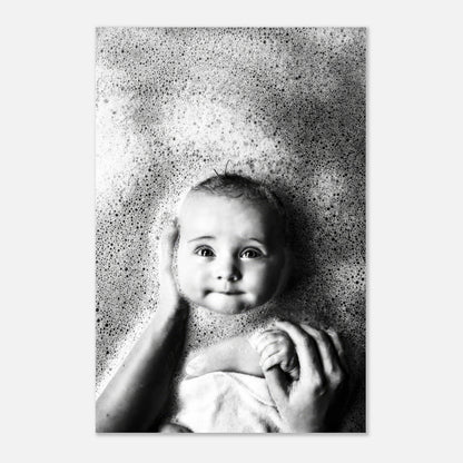 Baby in bath surrounded by bubbles, showcasing innocence and joy in black-and-white metal print.